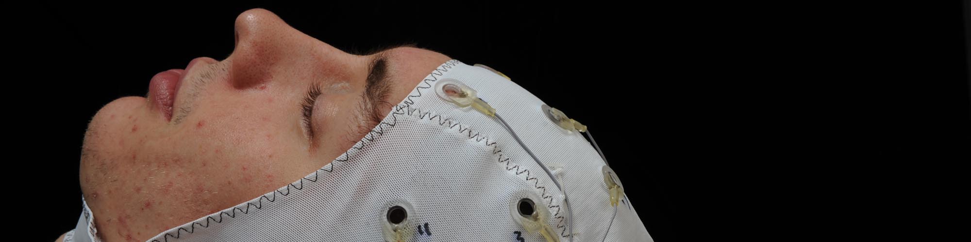 Julian Grove, manager of the Language Processing Laboratory at the University, wears a cap that is used with an EEG machine.