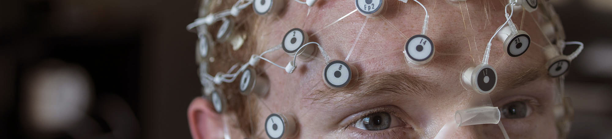 UChicago doctoral student Aaron Ball shows how a high-density EEG net is worn during a demonstration.