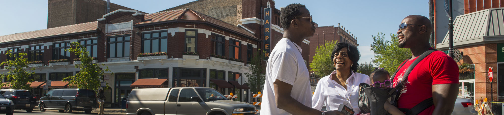 Friends Bryant Mclemore-Smith, left, and Makali Robinson, holding his daughter Nila, 6-mos., along with Robinson's mother-in-law Patricia Jordan, stop to chat at 53rd Street and S. Harper in Chicago's Hyde Park neighborhood.
