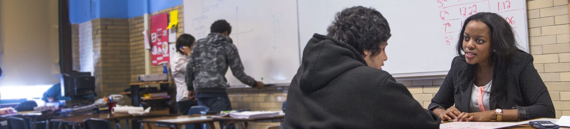 Match tutor Miriam Kamya works with a student at Edwin G. Foreman High School in Chicago.