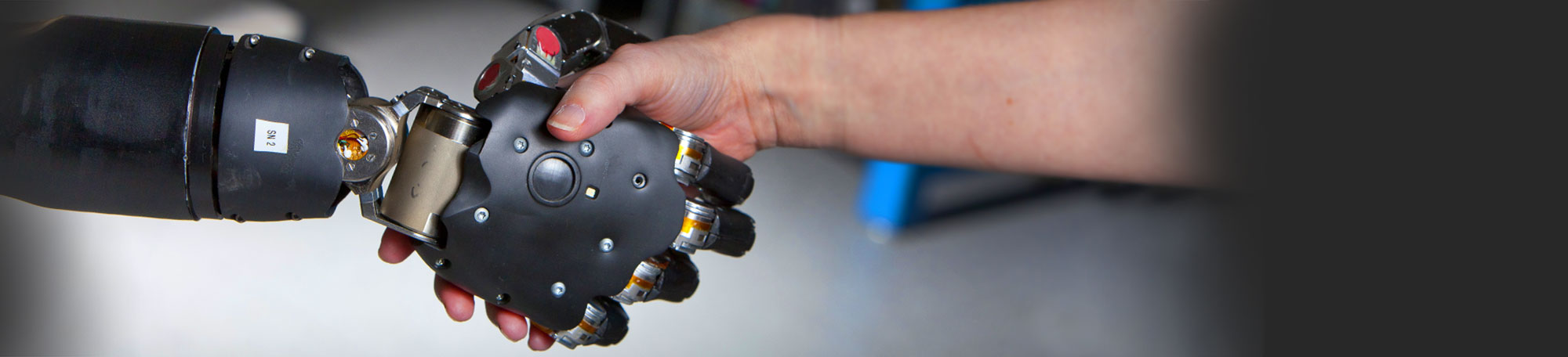 Robotic hand shakes human hand