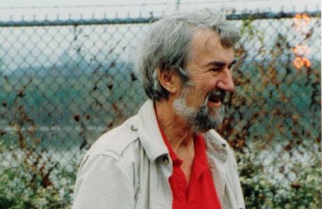 Courtenay Wright, in a jacket, stands in front of a wire fence.