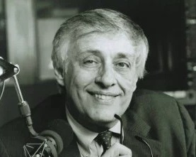Milton J. Rosenberg, in suit and tie, smiles wide.