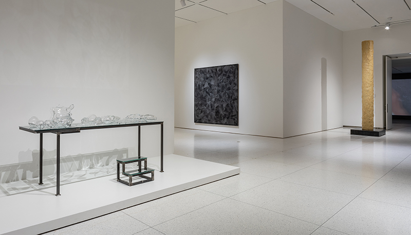 A table sits in an all white Smart Museum room.
