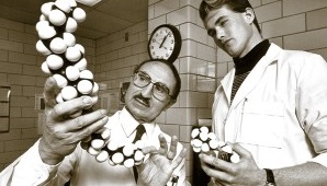 Angelo Scanu holds a molecular structure model while another person in a lab coat looks on.