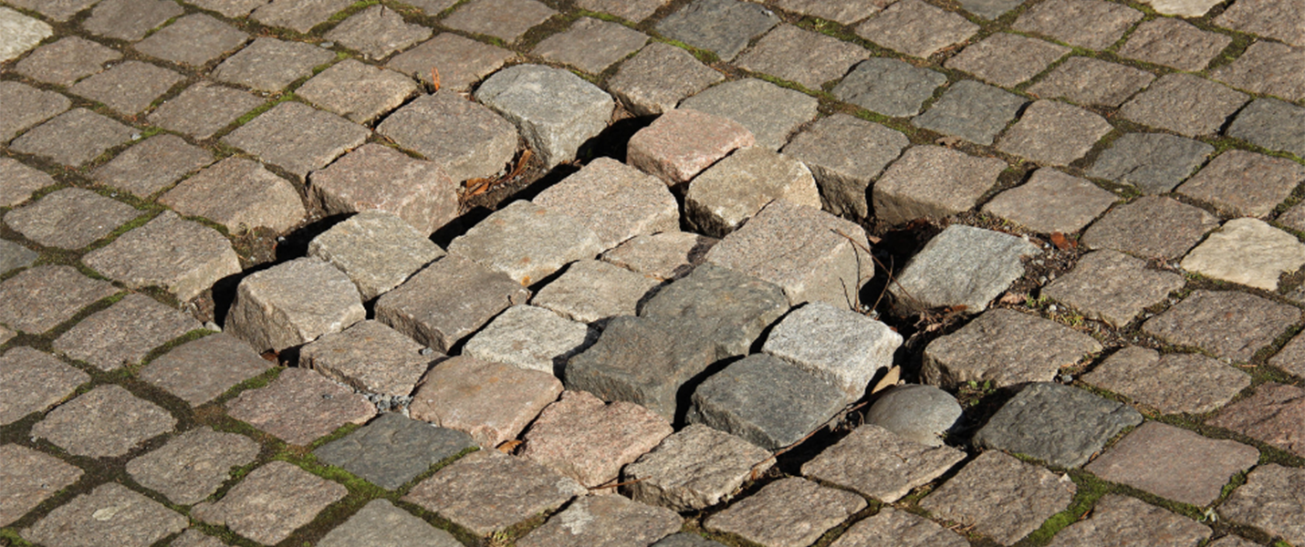 tightly packed cobblestones with a section of loose stones with gaps around them
