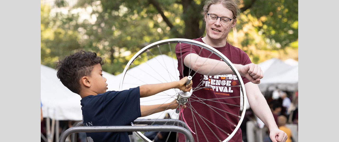 volunteer teaches science using bike wheel