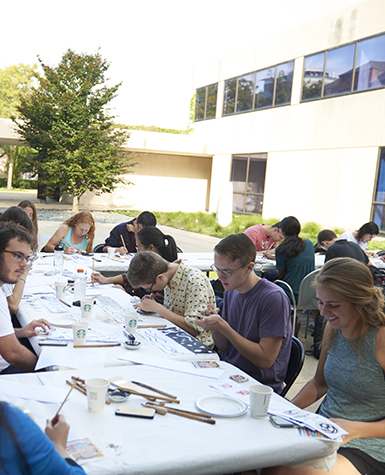 Students making art at a table outdoors