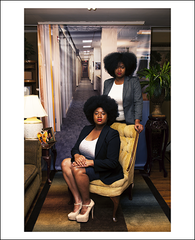A photographic portrait of two Black women in suits