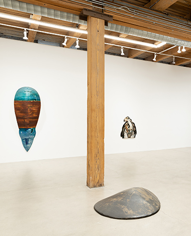 Fiberglass sculptures presented on the walls and floor of a gallery