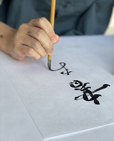 A person writing calligraphy with ink and brush