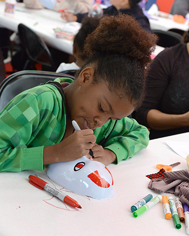 Family day participant creating a mask at the Smart Museum
