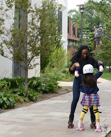 A skating instructor helps a child learn how to roller skate