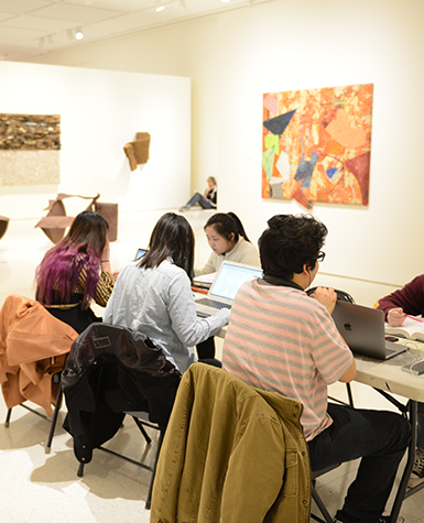 College students study around a table in the Smart Museum's galleries