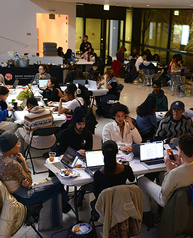 Students study around tables in a museum lobby