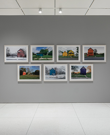 An installation of 7 photographs of differently colored houses